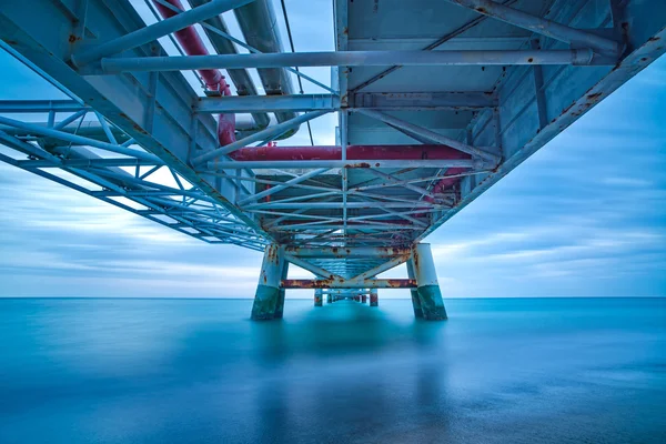 Jetée industrielle sur la mer. Vue du bas. Photographie longue exposition . — Photo