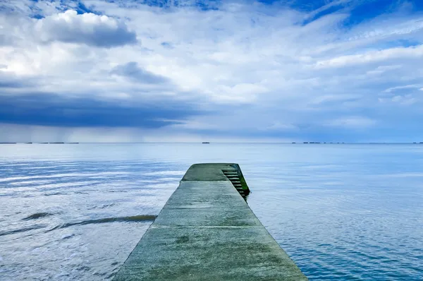 Pier concreto ou molhe em um mar azul e céu nublado. Normandia, França — Fotografia de Stock