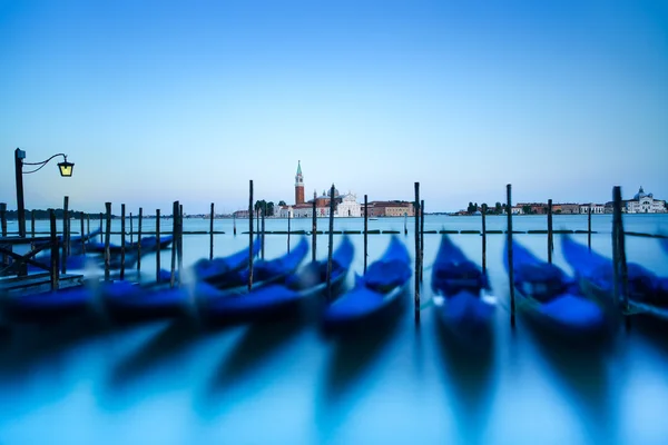 Wenecja, gondole lub gondole na zachód słońca i kościoła na tle. Włochy — Zdjęcie stockowe