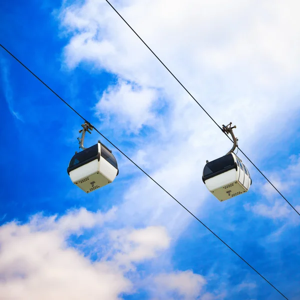 Två kabel bil på en delvis molnig himmel bakgrund — Stockfoto