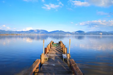 ahşap iskele veya iskelesi ve su bir mavi göl günbatımı ve gökyüzünün yansıması üzerinde. Versilia Toskana, İtalya