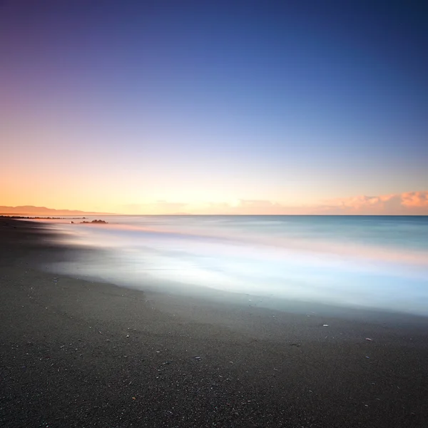 Praia areia escura e mar de manhã. Toscana Itália — Fotografia de Stock