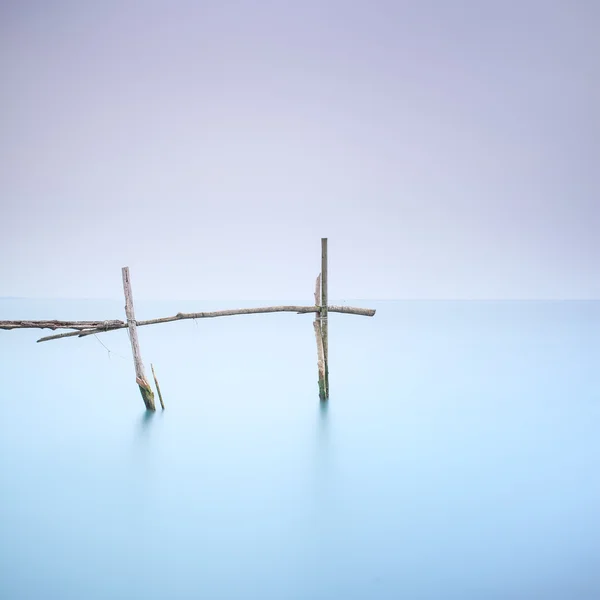 Poles and soft water on foggy landscape. Long exposure. — Stock Photo, Image