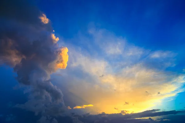 Dramatic sunset sky with yellow, blue and orange thunderstorm cl