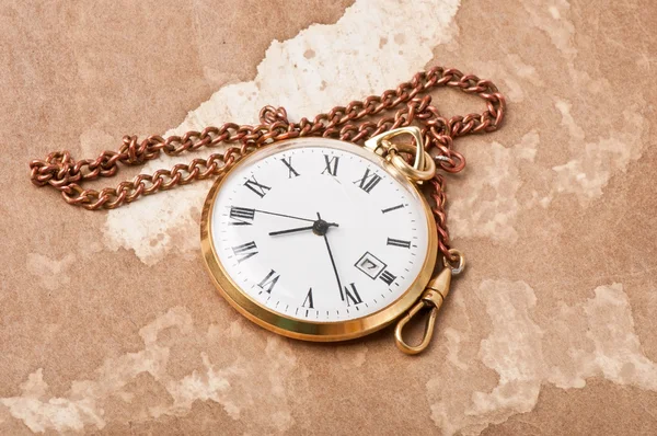 Old pocket watch on vintage paper — Stock Photo, Image