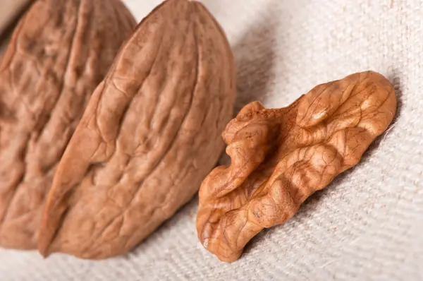 Грецкие орехи на фоне старой ткани — стоковое фото