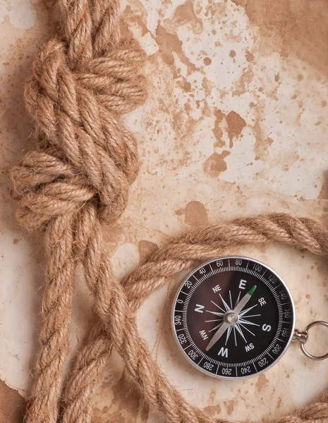 Knoop en kompas op oude papier achtergrond — Stockfoto