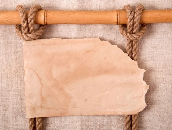 Knoop en oud papier op de achtergrond van oude doek — Stockfoto