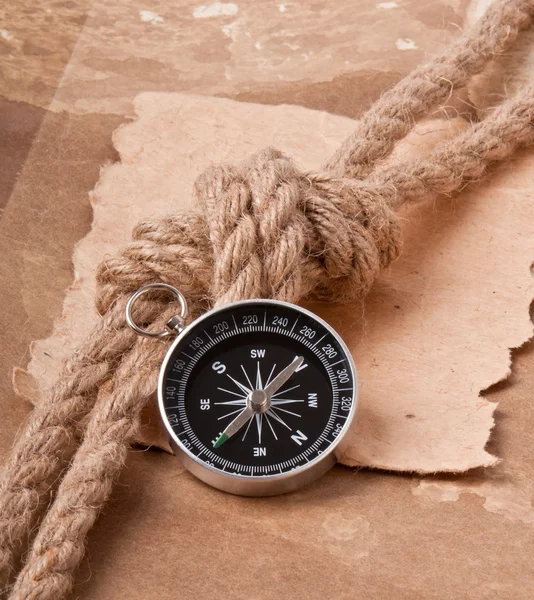 Knoop, een kompas en een papier op de achtergrond van oud papier — Stockfoto