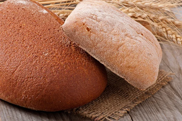 Frisches Brot und Weizenähren — Stockfoto