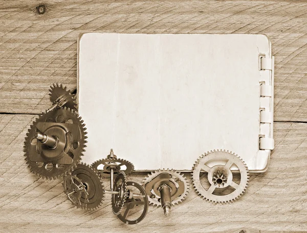 Notebook and gears of the clock — Stock Photo, Image