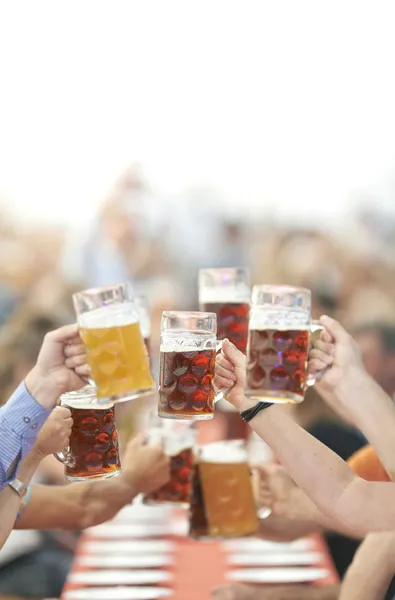 オクトーバーフェストのビールを飲むガラスを上げる ストック画像