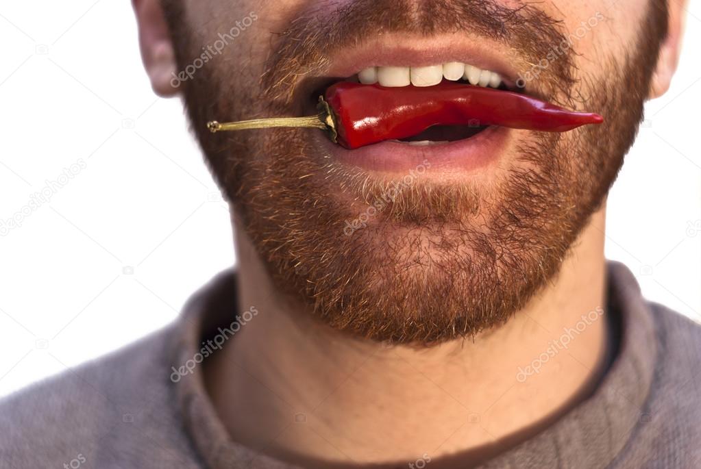 man with a red hot chili pepper in his mouth