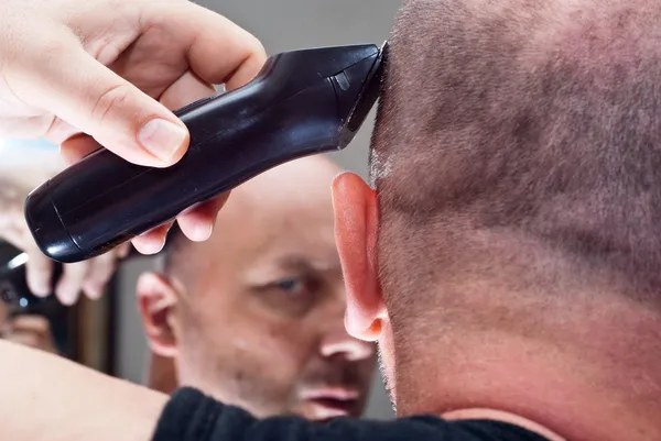 Homem no espelho corta seu cabelo — Fotografia de Stock