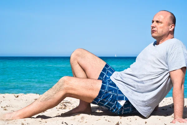 Man zittend op het strand om te ontspannen — Stockfoto