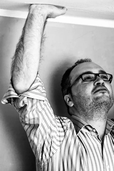 Man in striped shirt plafond met hand aanraken — Stockfoto