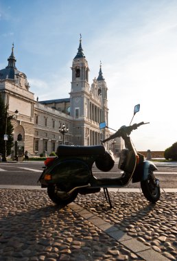 Italian scooter in Santa Maria la Real de La Almudena cathedral clipart