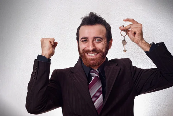 Happy businessman holding a house key — Stock Photo, Image