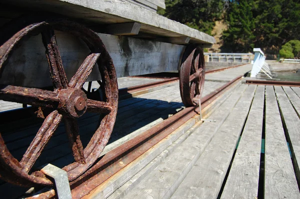 Metal wheels of old wagon on pier — Stock Photo, Image