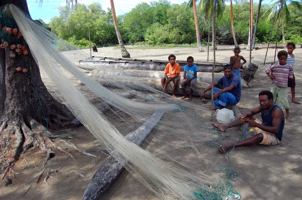 Fishermen cleaning net in Papua New Guinea village — Stock Photo, Image