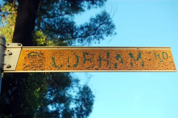 Snaky molten yellow metal street sign plate Australia — Stock Photo, Image