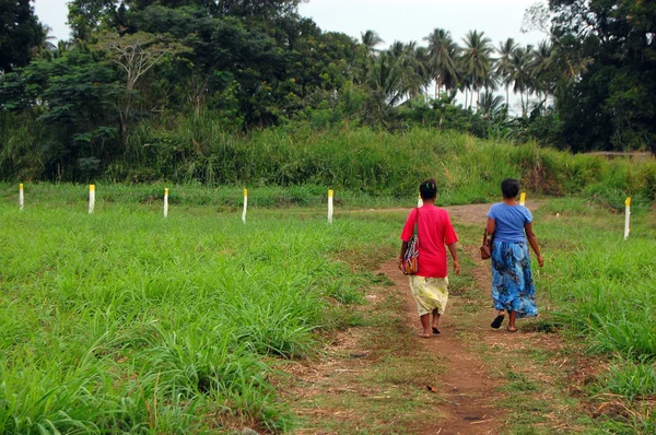 Duas mulheres caminham na estrada de cascalho — Fotografia de Stock