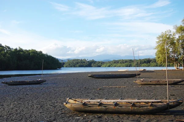 Timmer kanot på sand nära floden — Stockfoto