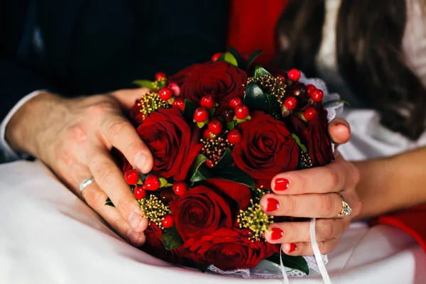 Ruce novomanželé drží svatební kytice — Stock fotografie