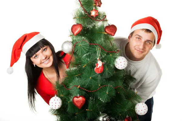 Man and woman looking out of Christmas tree — Stock Photo, Image