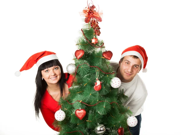 Man and woman looking out of Christmas tree — Stock Photo, Image
