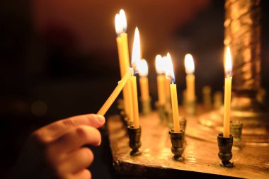 Küçük Çocuk kilise mumu yakıyor. Bir çocuk şapelde mum yakar.