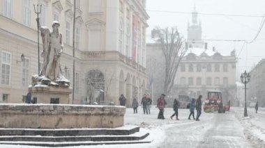 Lviv, Ukrayna - 6 Aralık 2021: Lviv 'deki pazar meydanında kar temizleme çalışmaları. Lviv 'e kar yağıyor. Kar Temizleme Makinesi Eylemde.