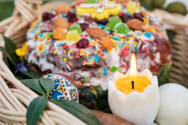 Geleneksel bayram yemekleriyle dolu Ukrayna Paskalya sepeti. Paskalya yemeği, paskalya yumurtası, peynir, tereyağı, jambon, Paskalya ekmeği ve sepet. Yeşil çayır üzerinde sepet.