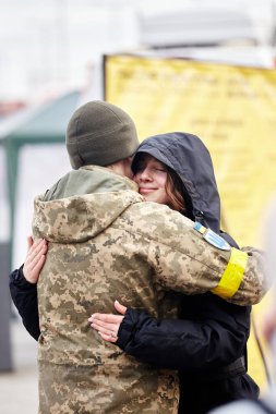 Lviv, Ukrayna - 9 Mart 2022. Lviv 'deki tren istasyonundaki Ukraynalı asker doğu cephesine gitmeden önce kız arkadaşını kucaklıyor. Ukrayna 'daki savaş sırasında tren istasyonunda vedalaşmalar