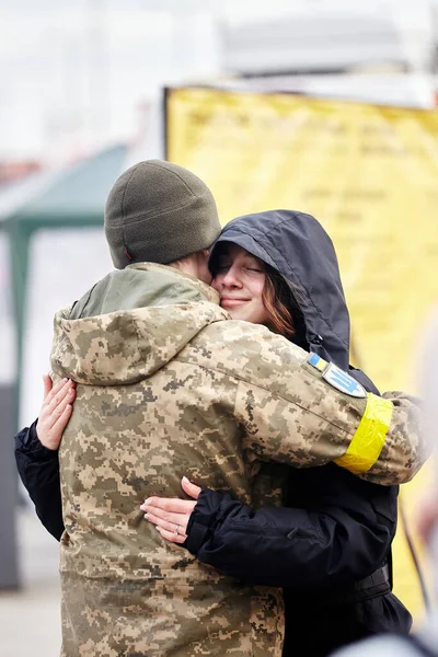 Lviv, Ukrayna - 9 Mart 2022. Lviv 'deki tren istasyonundaki Ukraynalı asker doğu cephesine gitmeden önce kız arkadaşını kucaklıyor. Ukrayna 'daki savaş sırasında tren istasyonunda vedalaşmalar