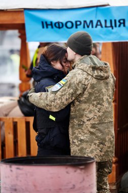 Lviv, Ukrayna - 9 Mart 2022. Lviv 'deki tren istasyonundaki Ukraynalı asker doğu cephesine gitmeden önce kız arkadaşını kucaklıyor. Ukrayna 'daki savaş sırasında tren istasyonunda vedalaşmalar
