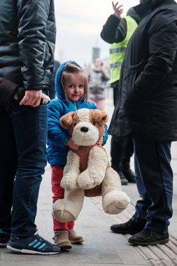 Lviv, Ukrayna - 09 Mar 2022. Yorgun küçük kız en sevdiği yumuşak oyuncağı tutuyor. Ukrayna 'daki savaş sırasında sivillerin tahliyesi