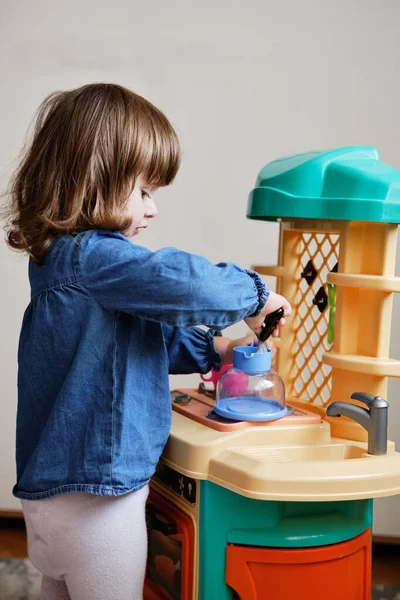 Linda Menina Para Interpretar Cozinheira Menina Brincando Cozinha Brinquedo Conjunto Fotografias De Stock Royalty-Free