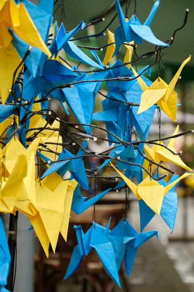 Japanese origami birds of peace blue and yellow concept of peace and help in the war. Concept of the Independence Day of Ukraine. Selective focus.