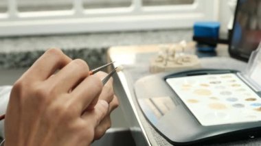 Diş teknisyeninin diş boyama protezi ve laboratuarda boya fırçası. Dişlerin estetik renkleri. Üretim yapan implantlar kavramı.