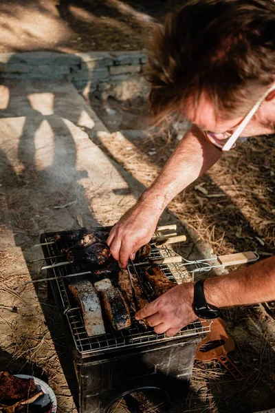 Parktaki aile eğlencesi: İnsanlar güzel sıcak havanın tadını çıkarıyor ve lezzetli yemekler hazırlıyorlar.