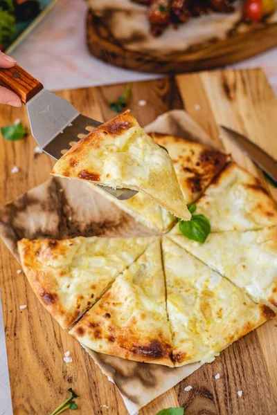 Cocina georgiana tradicional de Khachapuri con queso suluguni, servido en la mesa ligera con especias y espátula de madera —  Fotos de Stock