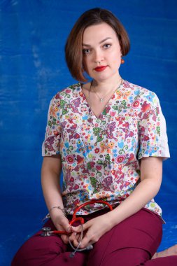 Steteskoplu mavi arka planda bir çocuk doktorunun fotoğrafı.