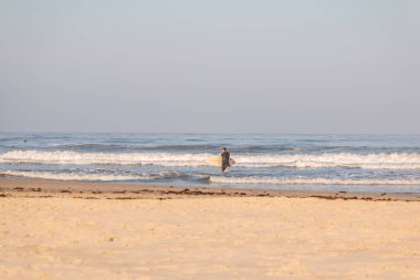 Torres sahilindeki okyanus dalgalarının tadını çıkaran sörfçüler.