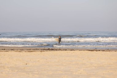 Torres sahilindeki okyanus dalgalarının tadını çıkaran sörfçüler.