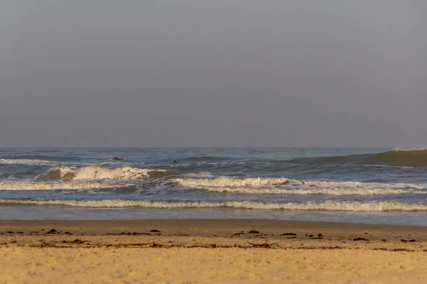 Torres sahilindeki okyanus dalgalarının tadını çıkaran sörfçüler.