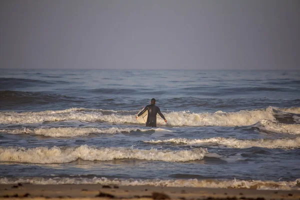 Torres sahilindeki okyanus dalgalarının tadını çıkaran sörfçüler.