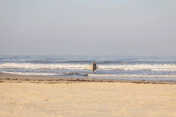 Torres sahilindeki okyanus dalgalarının tadını çıkaran sörfçüler.