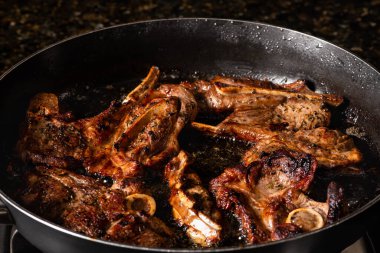 Kızartma tavasında kuzu filetosu pişirmek. Gaz ocağında yemek pişirmek..