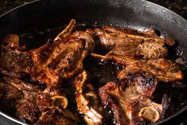 Kızartma tavasında kuzu filetosu pişirmek. Gaz ocağında yemek pişirmek..